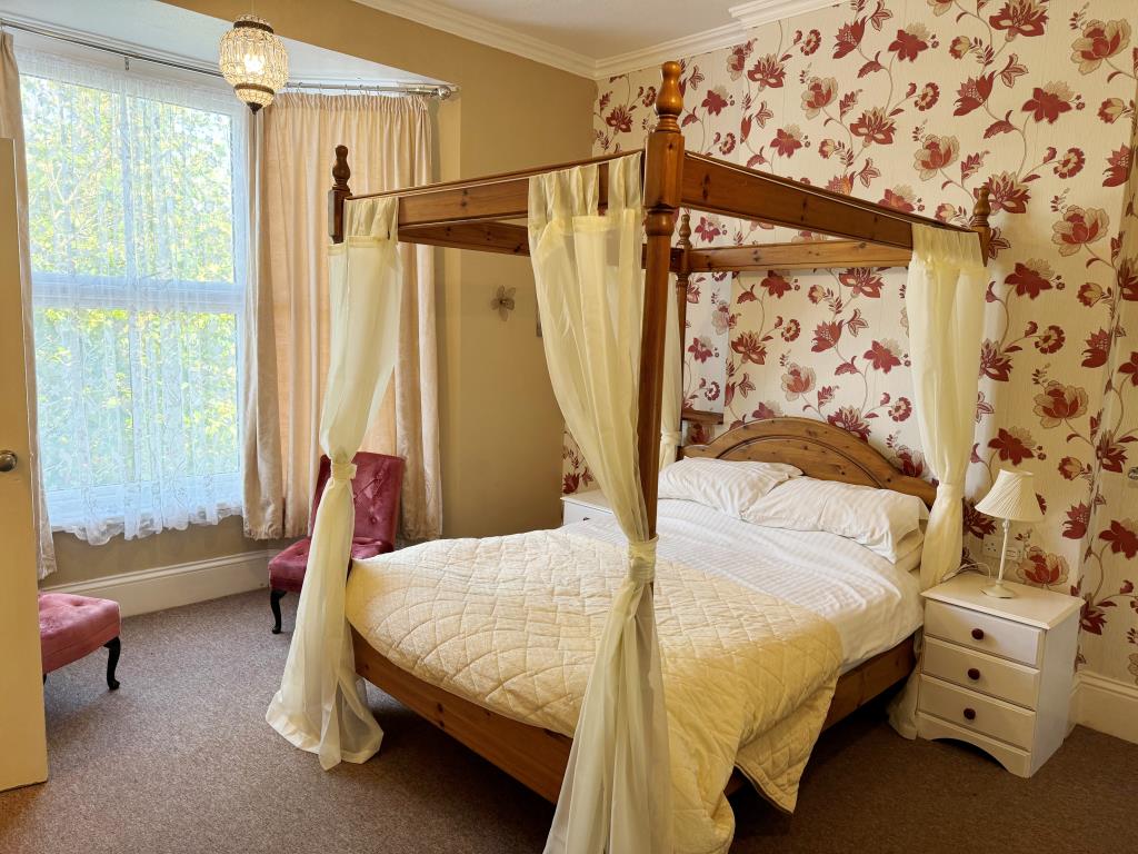Lot: 102 - FREEHOLD GUEST HOUSE WITH 11 GUEST ROOMS AND SEPARATE OWNER'S ACCOMODATION - Bedroom with four poster bed